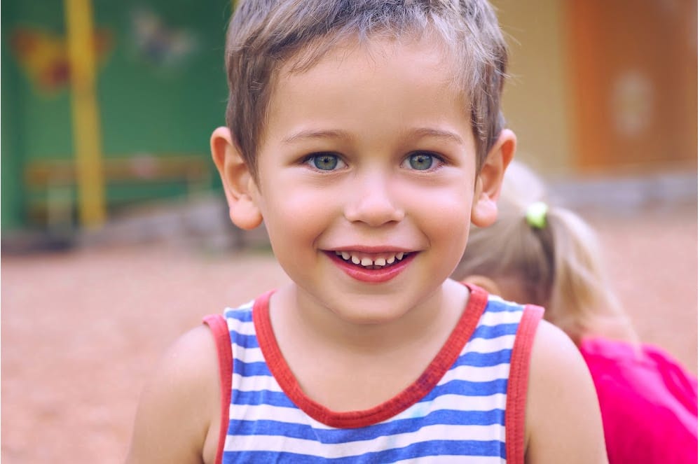 Smiling toddler in a playground.