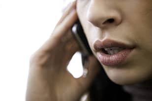 Woman's mouth, talking on a cell phone.