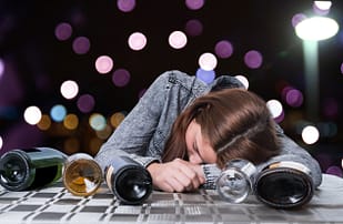 Alcoholic teen in a bar drinking.