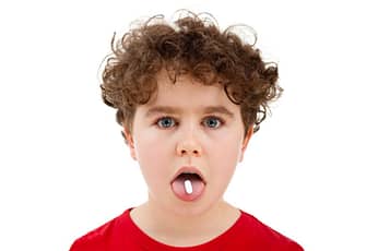 Boy with pill on his tongue.