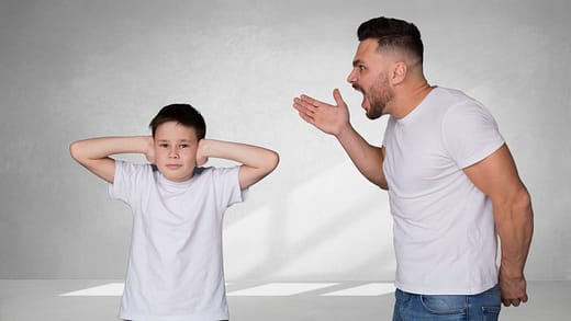 Father yelling at son, son covers his ears.
